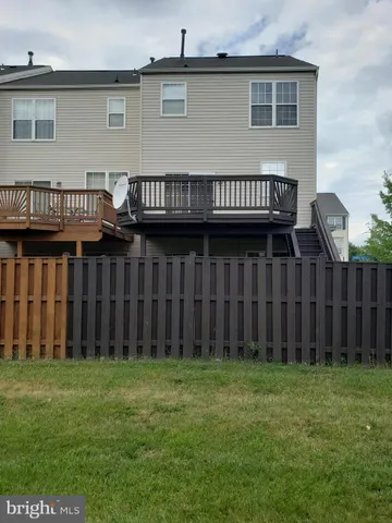 a view of a house with wooden deck and a garden