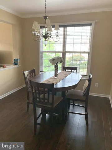 a dining room with furniture a chandelier and wooden floor