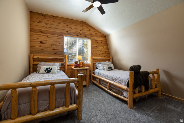 1505 West Elk Ridge Drive Alton, UT 84710 - Photo 26 of 53 Bedroom with wood walls, lofted ceiling, a textured ceiling, carpet flooring, and ceiling fan