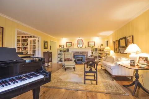 a living room with furniture and a piano