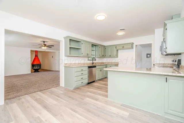 a kitchen with granite countertop a sink and a stove top oven with wooden floor