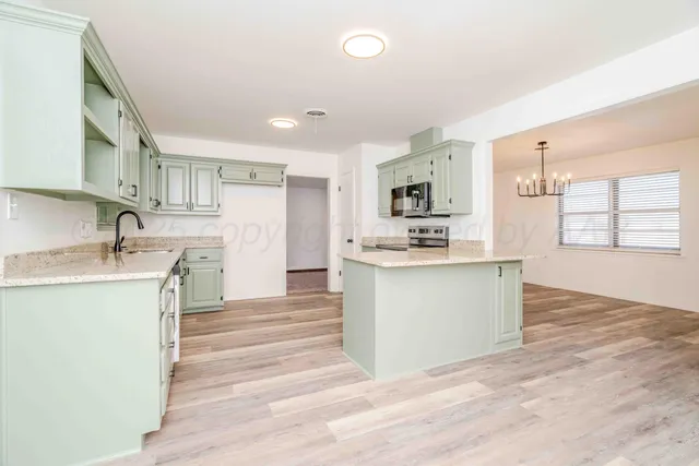 a kitchen with stainless steel appliances a stove microwave and refrigerator