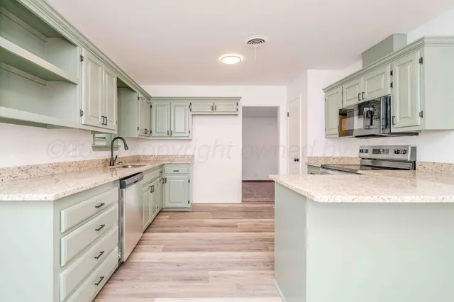 a kitchen with white cabinets and stainless steel appliances