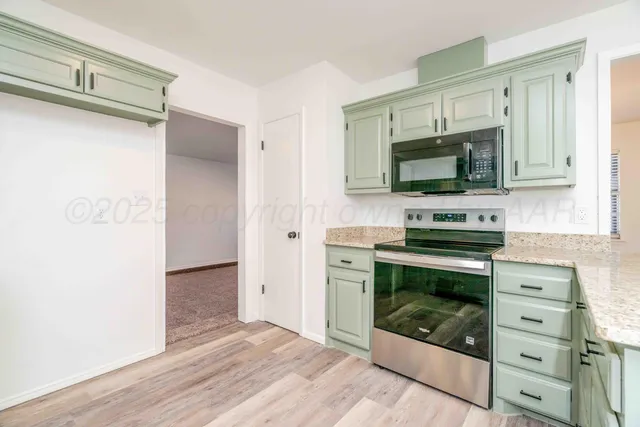 a kitchen with granite countertop white cabinets and a sink