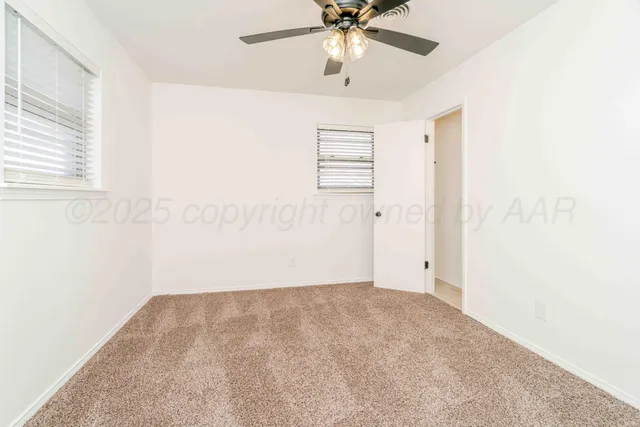 a view of a room with a ceiling fan and wooden floor