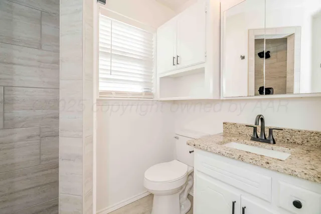 a view of a big room with windows and chandelier fan