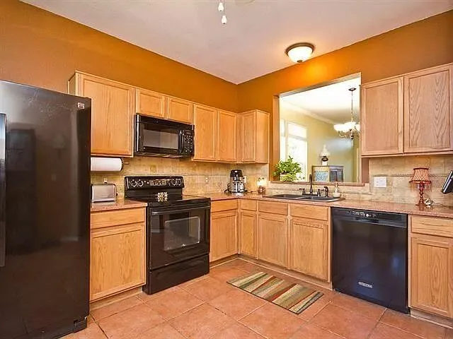 a kitchen with stainless steel appliances granite countertop a stove top oven a sink and dishwasher a refrigerator with wooden floor