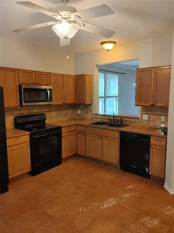 a kitchen with a stove a sink and a microwave