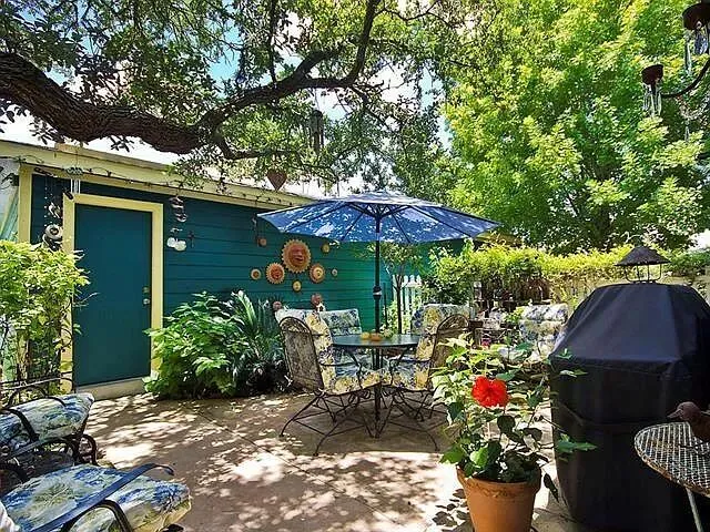 a view of a patio with table and chairs under an umbrella