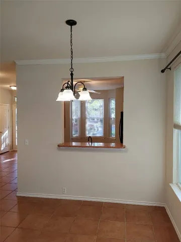 a view of a room with a chandelier fan and wooden floor