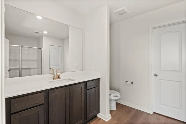 a bathroom with a granite countertop sink a toilet and a large mirror