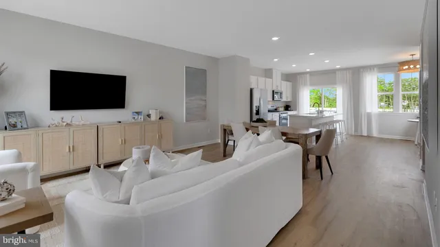 a living room with furniture a flat screen tv and a large window