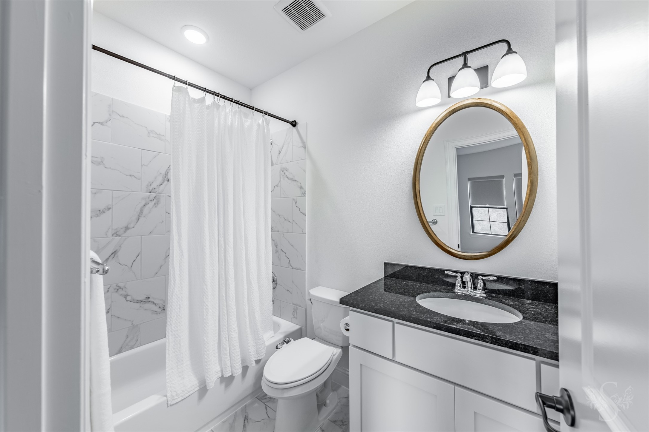 27919 Indigo Ridge Drive Fulshear, TX 77441 - Photo 37 of 50 This light and airy bathroom features a sleek granite vanity, fresh white cabinetry, and a tub/shower combo lined with elegant marble-look tile. Soft natural tones and updated fixtures create a welcoming space perfect for guests or family.