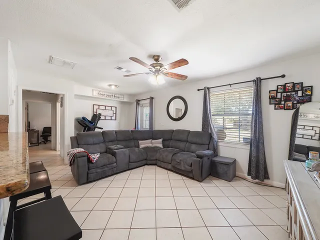 a living room with couch and dresser with wooden floor