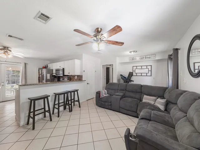 a living room with furniture and a view of kitchen