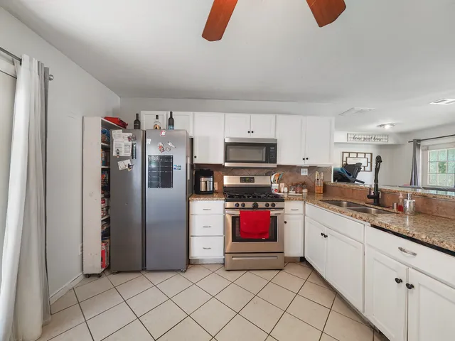 a kitchen with stainless steel appliances granite countertop a refrigerator and a stove top oven