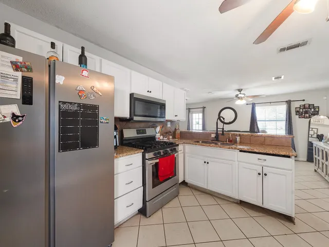a kitchen with stainless steel appliances a stove refrigerator sink and microwave