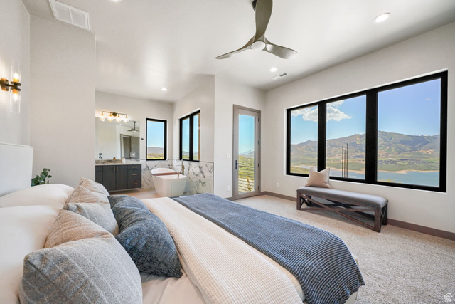 10646 North Reflection Ridge Hideout, UT 84036 - Photo 28 of 43 Spacious room featuring multiple large windows, a freestanding soaking tub, dual vanity, and a ceiling fan