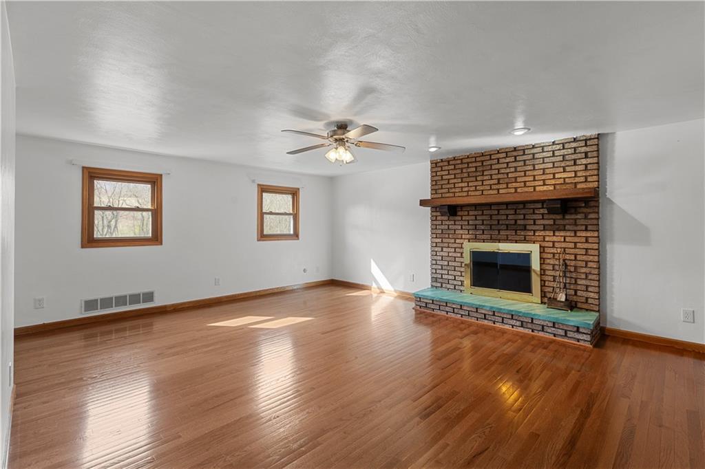 2807 Russelton Road Tarentum, PA 15084 - Photo 18 of 28 an empty room with wooden floor a fireplace and windows