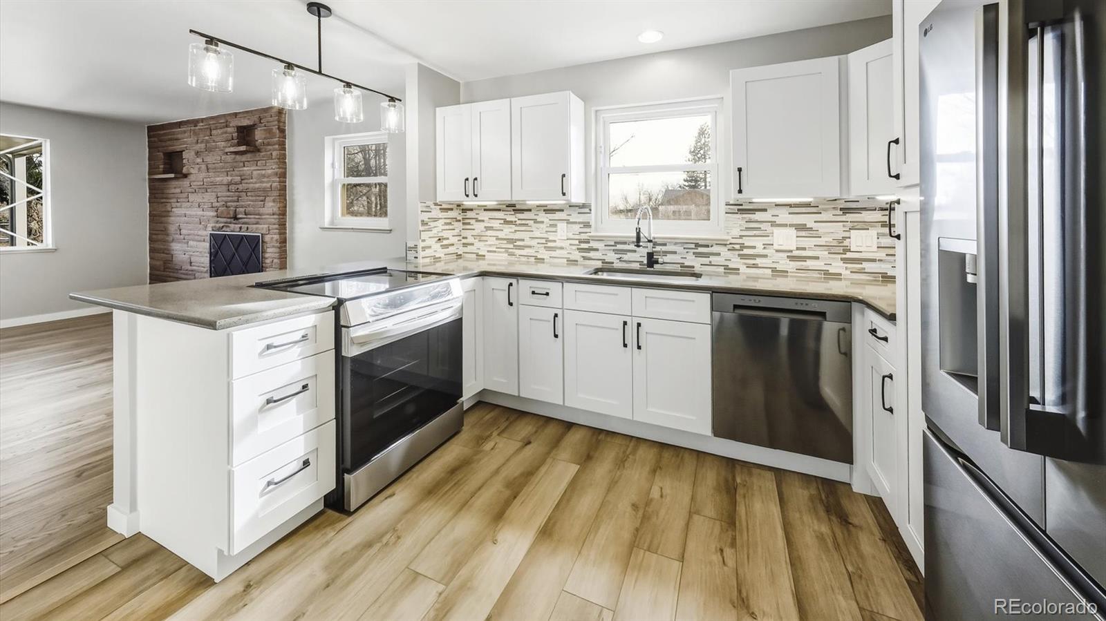 1201 Reed Street Lakewood, CO 80214 - Photo 13 of 44 a kitchen with stainless steel appliances granite countertop a stove sink and cabinets