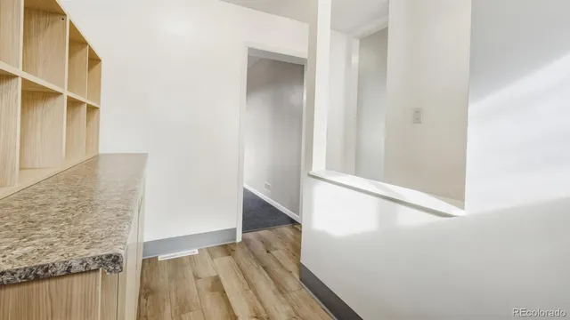 a view of a hallway with wooden floor and entryway