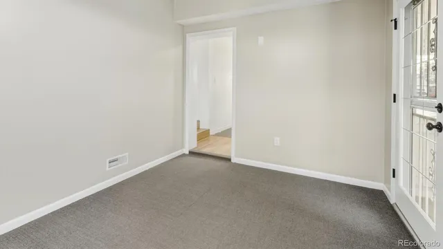 a view of an empty room with wooden floor
