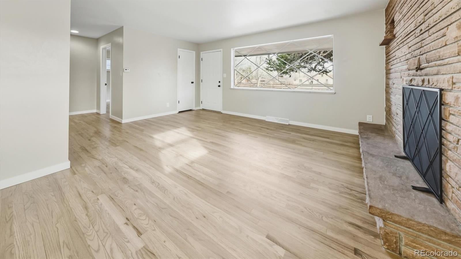 1201 Reed Street Lakewood, CO 80214 - Photo 9 of 44 an empty room with wooden floor and a window