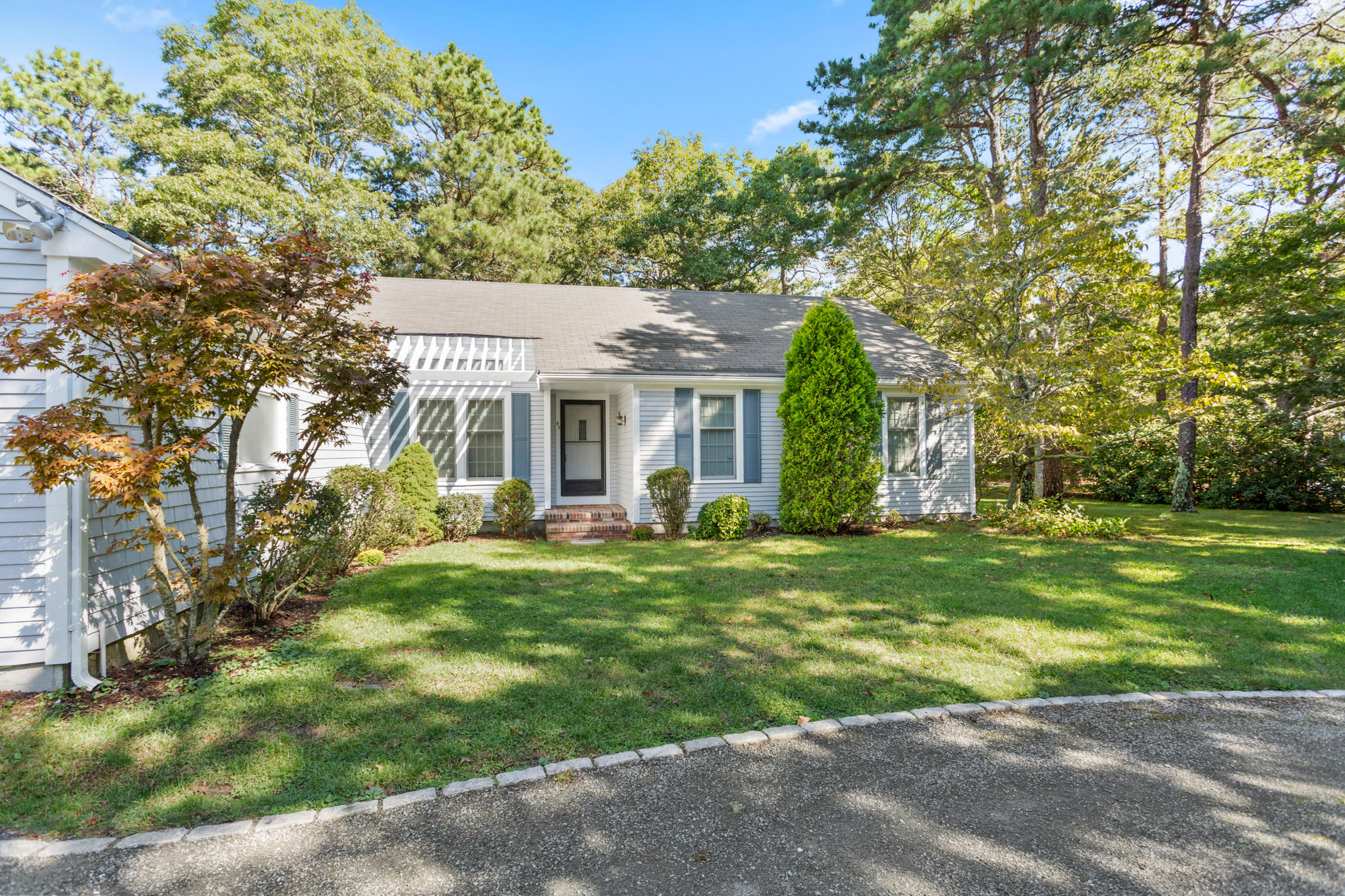82 Clamshell Cove Road Cotuit, MA 02635 - Photo 2 of 34 a front view of a house with a garden