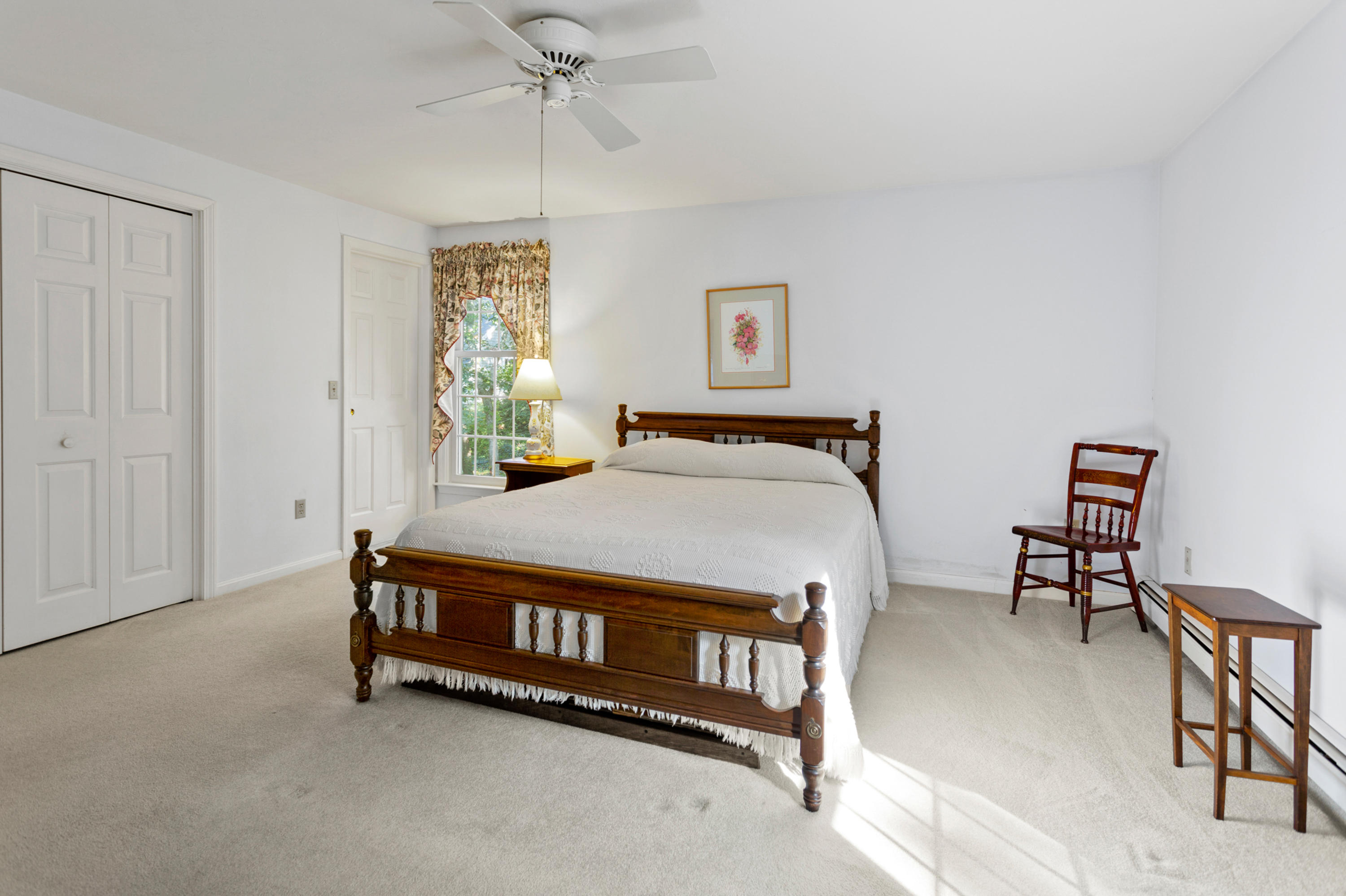 82 Clamshell Cove Road Cotuit, MA 02635 - Photo 28 of 34 a bed sitting in a room next to a window and a chandelier