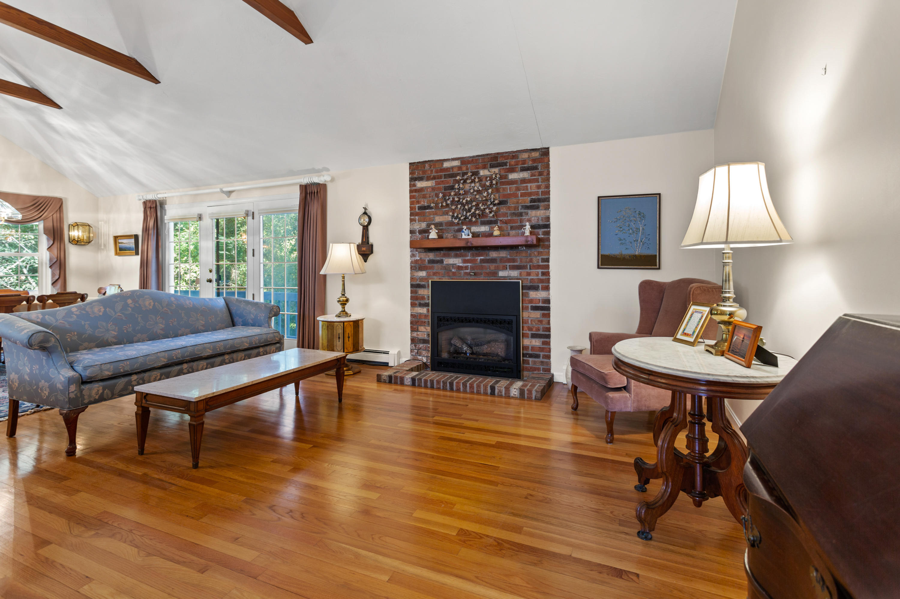 82 Clamshell Cove Road Cotuit, MA 02635 - Photo 6 of 34 a living room with furniture a table and a fireplace