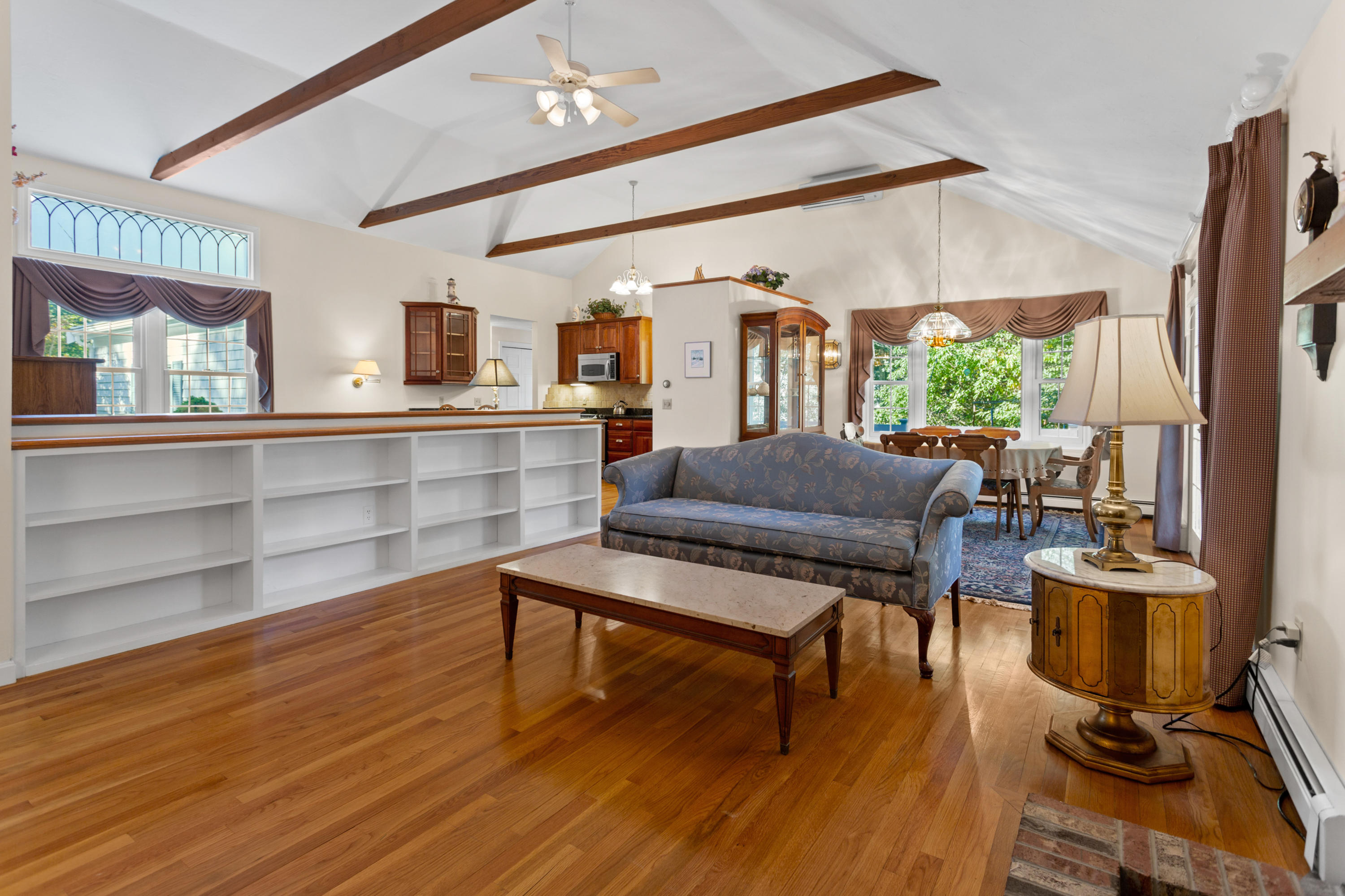 82 Clamshell Cove Road Cotuit, MA 02635 - Photo 8 of 34 a living room with furniture a flat screen tv and a floor to ceiling window