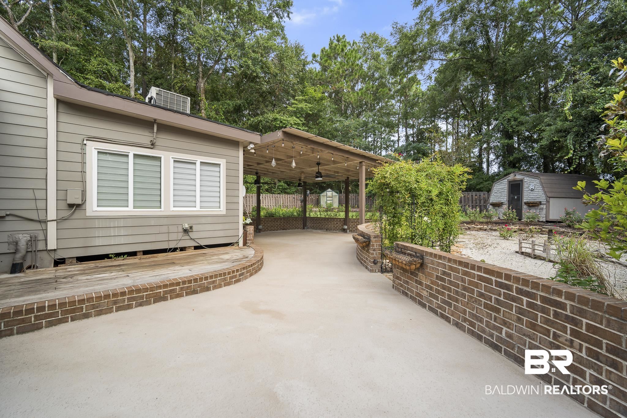 178 Lakeview Loop Daphne, AL 36526 - Photo 34 of 43 View of patio featuring a shed, view of scattered trees, and a carport