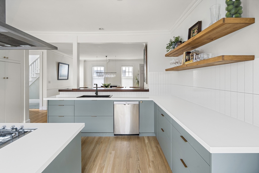 16 Blake Street Cambridge, MA 02140 - Photo 11 of 37 a kitchen with a sink dishwasher a stove and white cabinets with wooden floor
