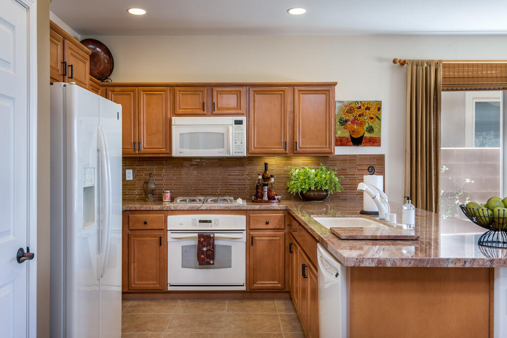 81820 Eagle Claw Drive La Quinta, CA 92253 - Photo 8 of 36 a kitchen with stainless steel appliances granite countertop a stove a sink and a refrigerator