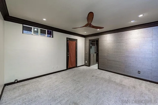 an empty room with wooden floor cabinet and windows