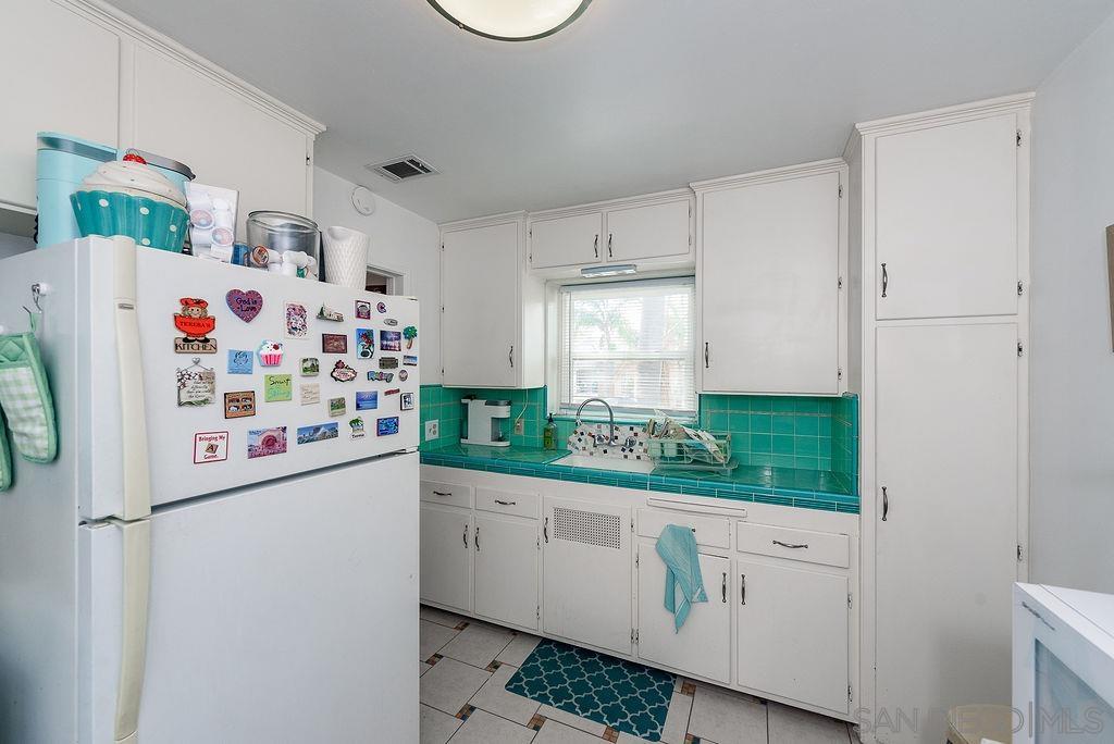 2414 Monroe Avenue San Diego, CA 92116 - Photo 51 of 65 a white refrigerator freezer sitting inside of a kitchen
