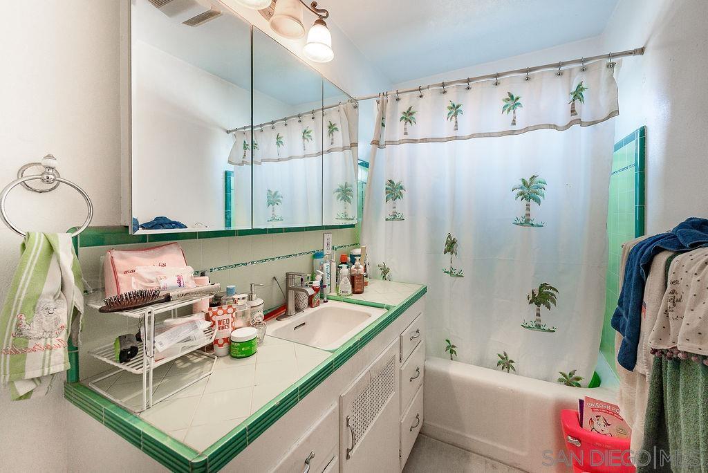 2414 Monroe Avenue San Diego, CA 92116 - Photo 65 of 65 a bathroom with a sink a mirror and a shower curtain