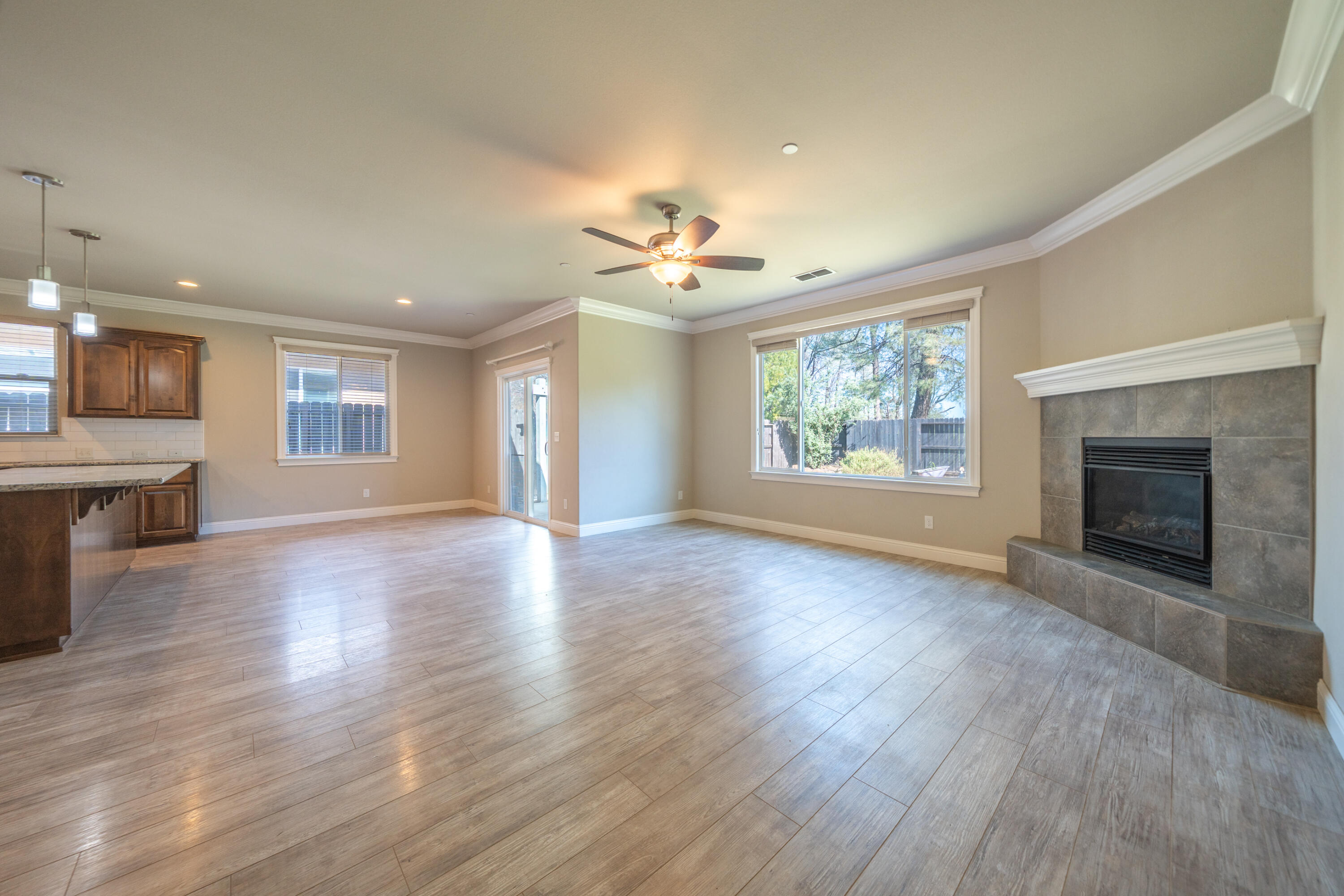5571 Muir Peak Road Redding, CA 96002 - Photo 11 of 42 an empty room with wooden floor fireplace and windows