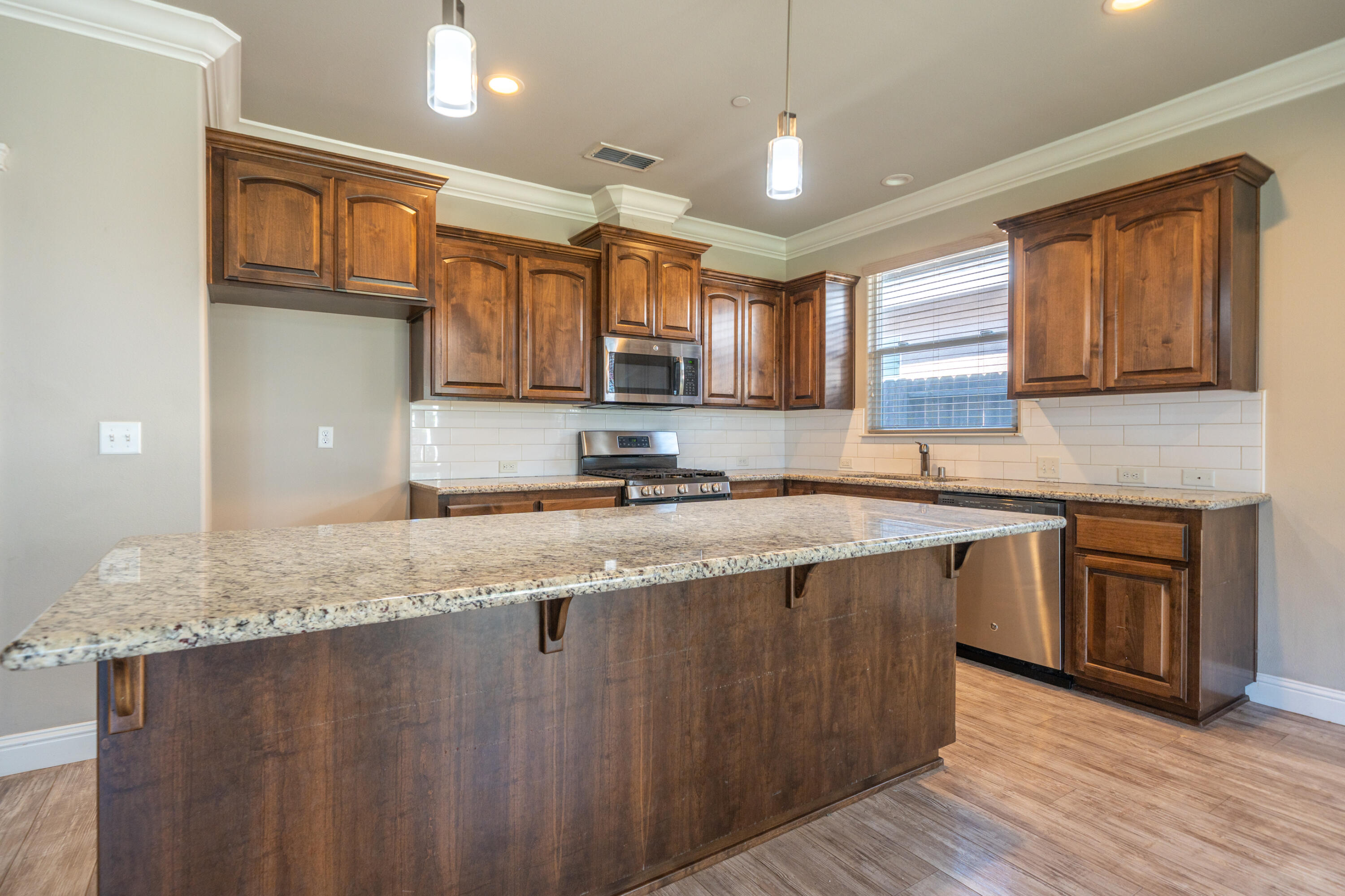 5571 Muir Peak Road Redding, CA 96002 - Photo 16 of 42 a kitchen with stainless steel appliances granite countertop a sink a stove and a wooden cabinets