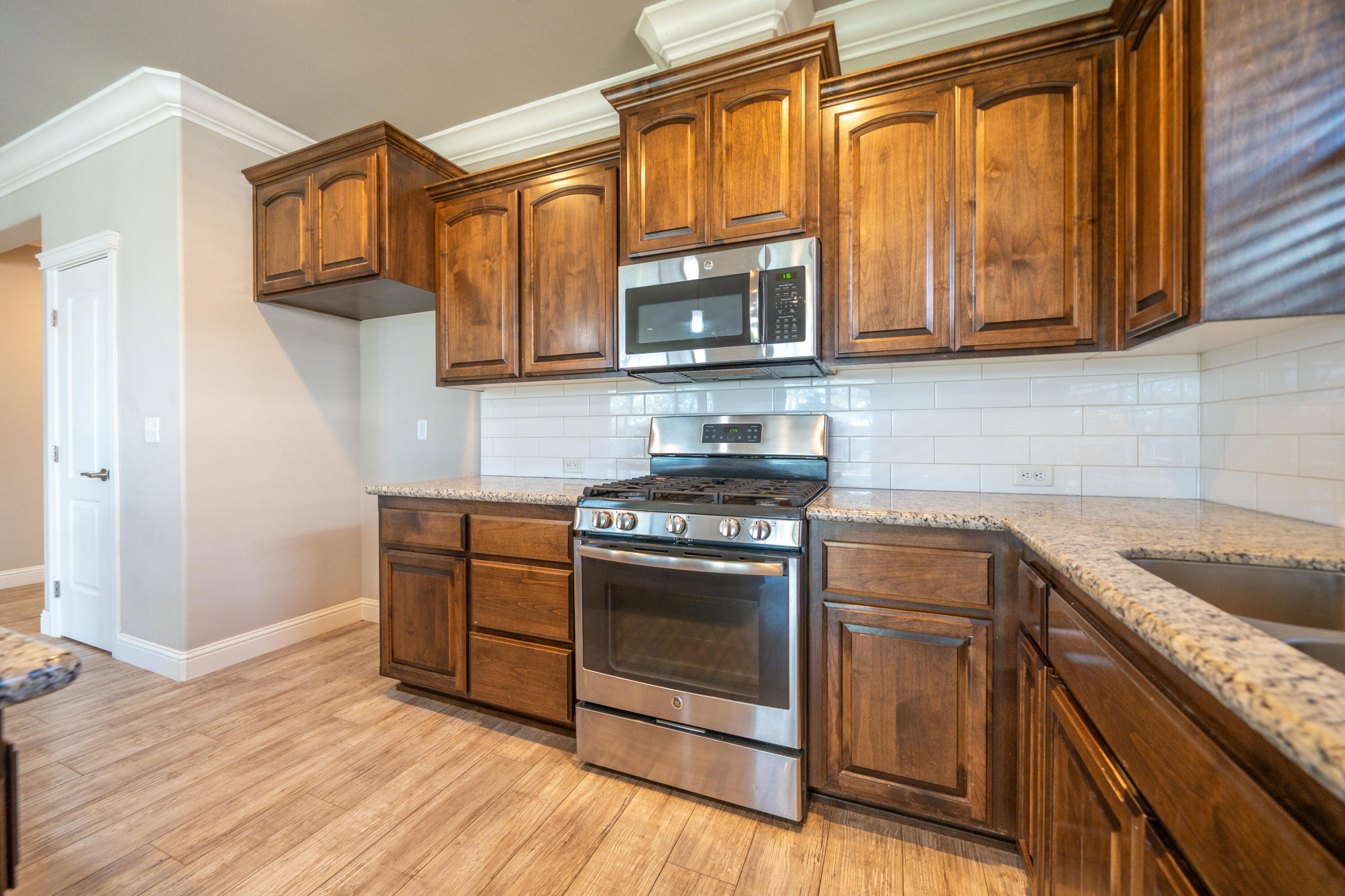 5571 Muir Peak Road Redding, CA 96002 - Photo 20 of 42 a kitchen with stainless steel appliances granite countertop a stove a sink and a microwave