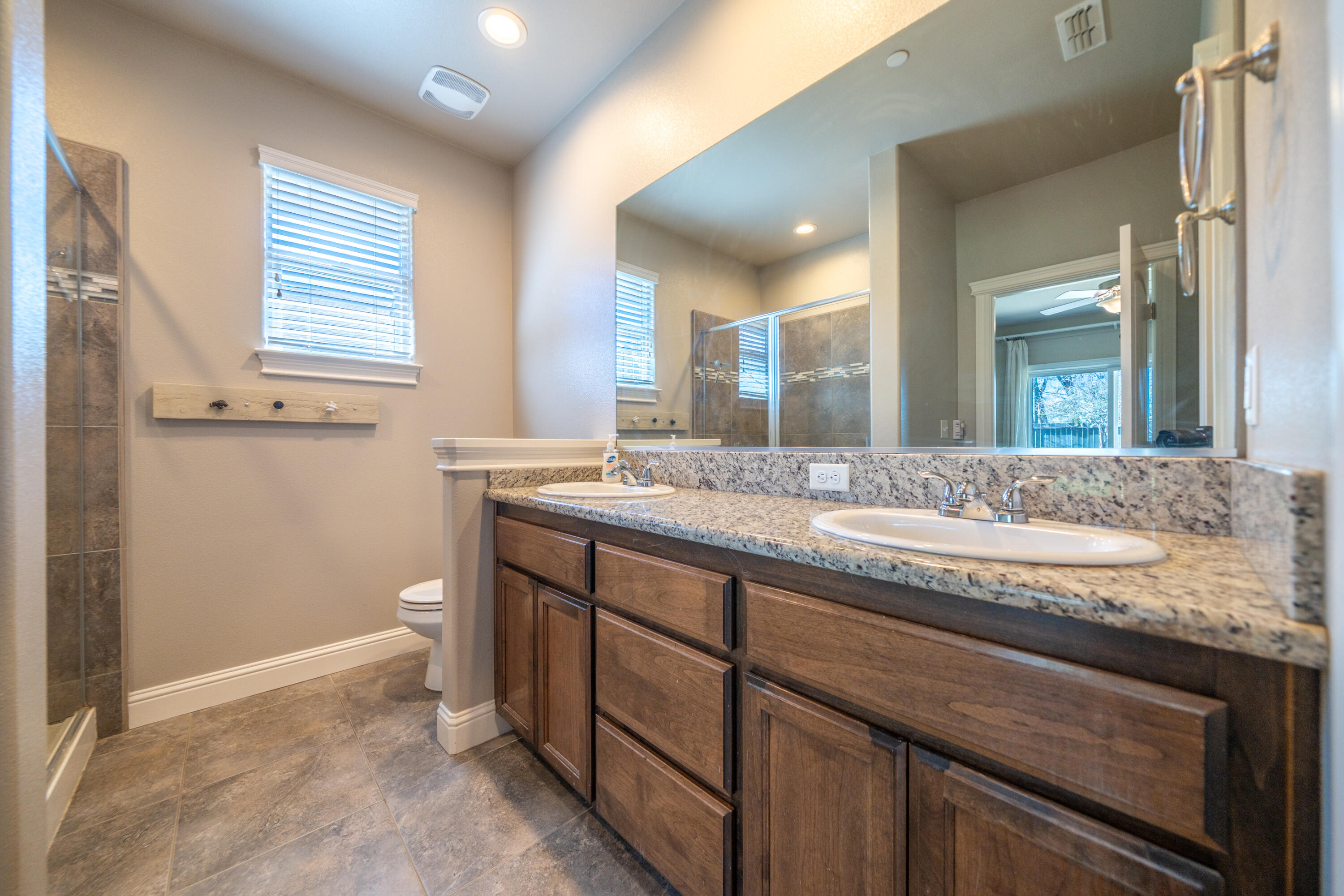 5571 Muir Peak Road Redding, CA 96002 - Photo 24 of 42 a bathroom with a granite countertop sink and a mirror