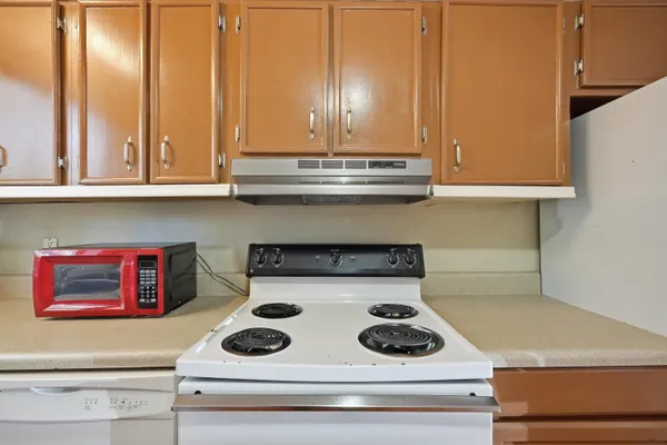 a white refrigerator freezer and a stove sitting inside of a kitchen