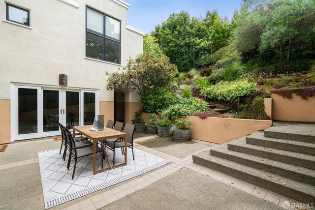 a view of a patio with table and chairs and potted plants