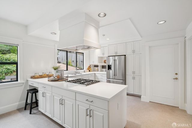 a kitchen that has a lot of cabinets a sink and appliances