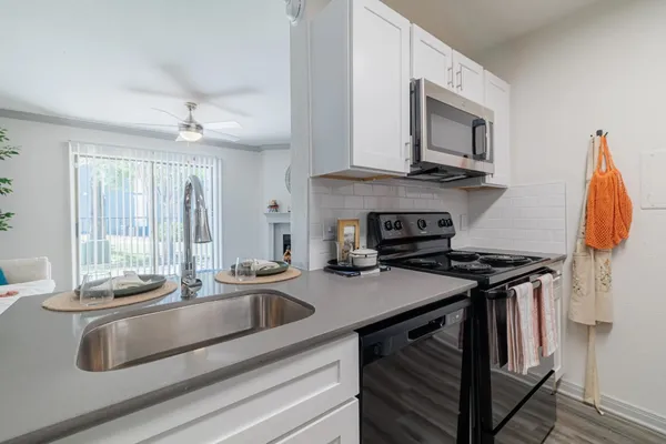 a kitchen with stainless steel appliances granite countertop a sink stove and microwave