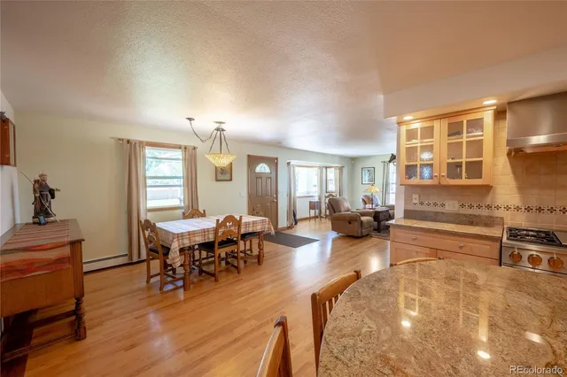 a living room with furniture a dining table and chairs with wooden floor