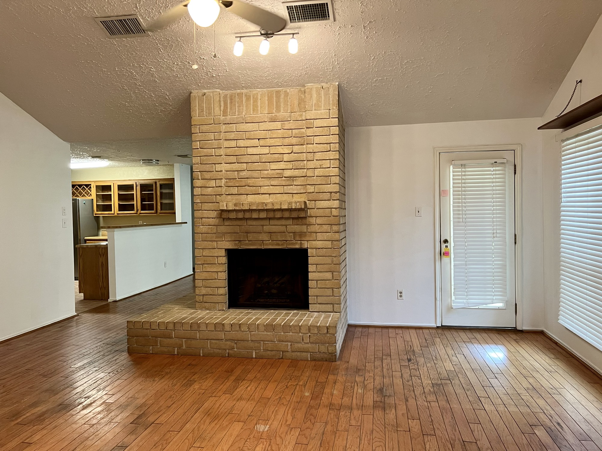 3702 Echo Grove Lane Houston, TX 77043 - Photo 15 of 18 an empty room with wooden floor fireplace and windows
