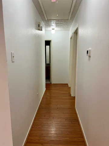a view of a hallway with wooden floor