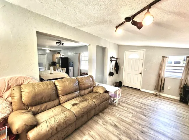 a living room with furniture and wooden floor