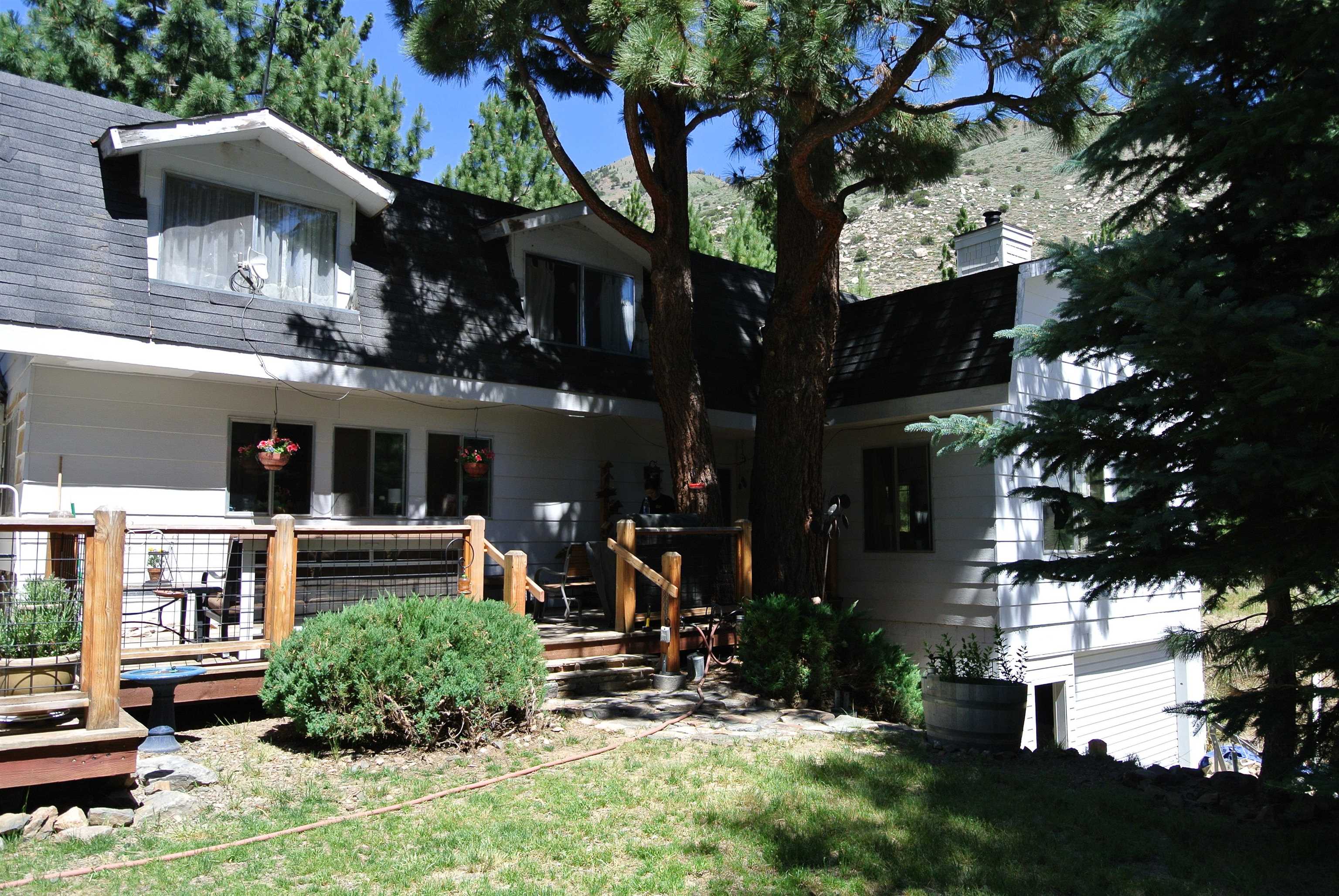 11702 Twin Lakes Road Bridgeport, CA 93517 - Photo 2 of 21 Rear exterior featuring a multi-level wooden deck with metal railing, dormer windows, and a black shingle roof